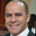 Retrato profissional de homem sorridente em ambiente interno