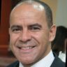 Retrato profissional de homem sorridente em ambiente interno