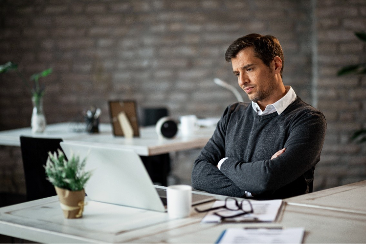 Homem em escritório de contabilidade com expressão de estresse.