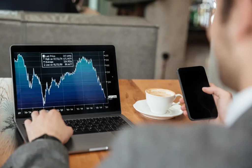 Profissional analisando gráficos de mercado e impactos econômicos no notebook, ilustrando o acompanhamento das atualizações fiscais e as penalidades da Reforma Tributária abordadas no boletim Fiscal News.