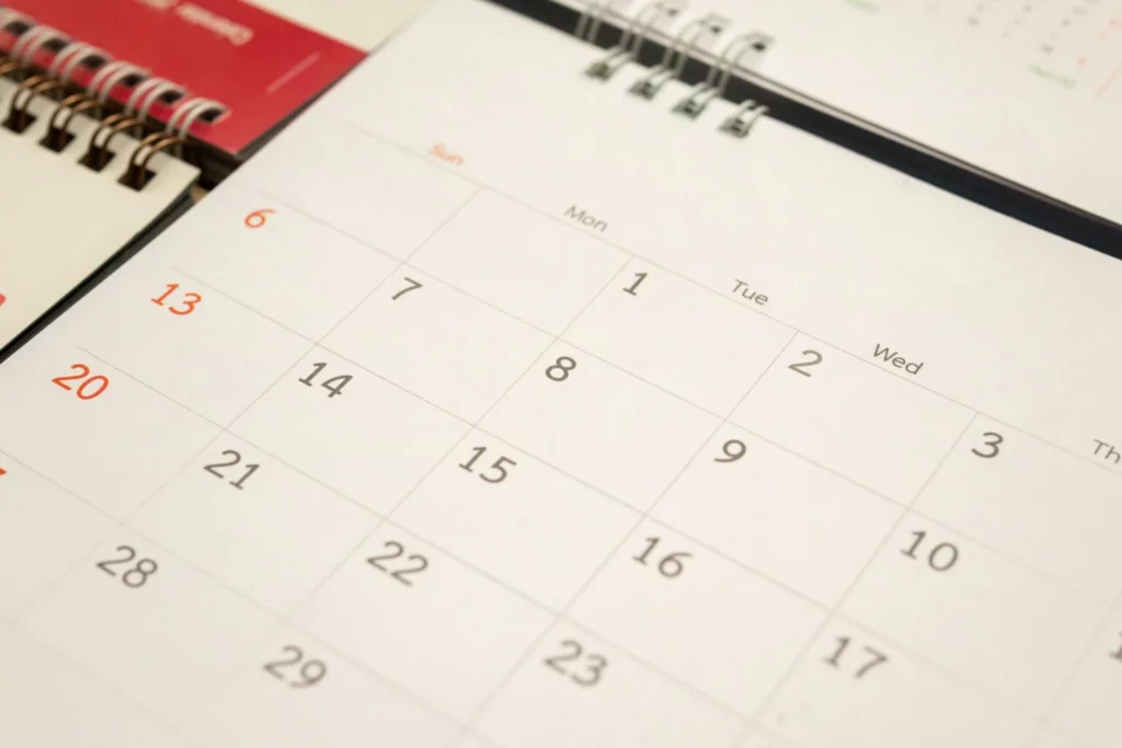 Close-up de um calendário de mesa aberto, exibindo os dias do mês organizados em uma grade semanal.
